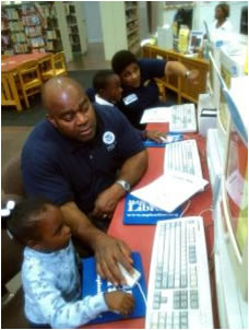 Mobile, Ala., Dec. 11, 2004 Mobile, AL - Federal Coordinating Officer Tony Russell teaches Annzwanetta Clark, 4, of Mobile, about the FEMA for Kids website at the Mobile Public Library Holiday Open House. FEMA Photo/Amanda Bicknell. 